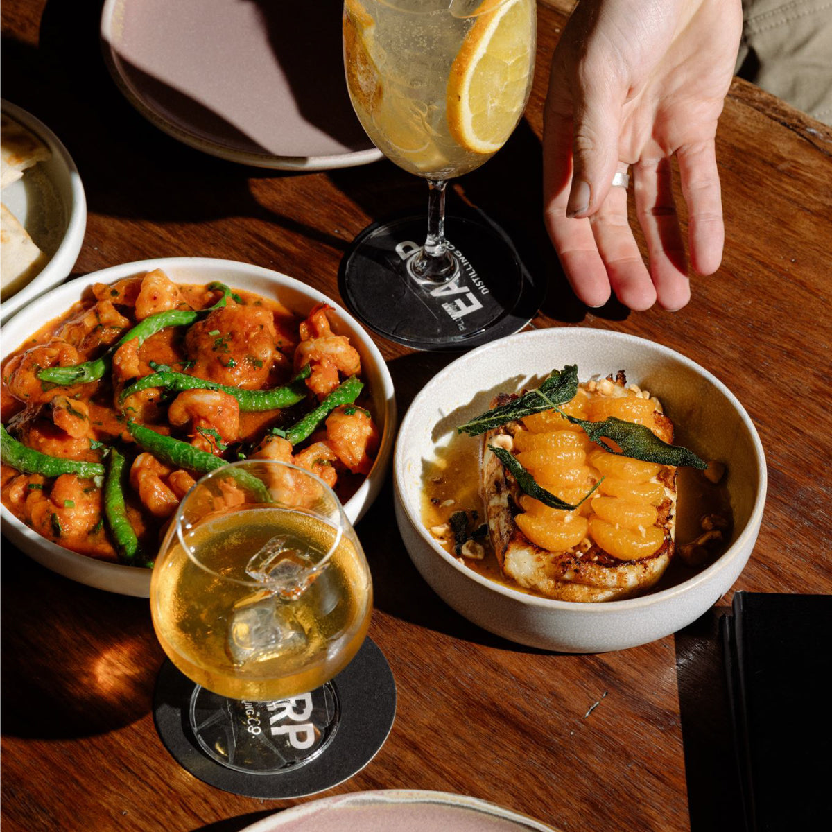 Two small dishes are placed in front of diners at Earp Distillery