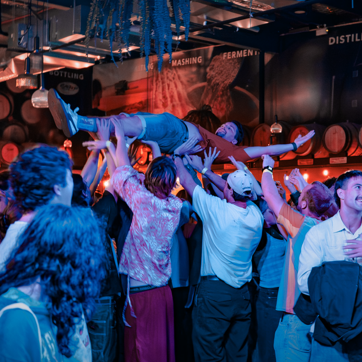 A crowd lifts a concert goer during a live music event in Earp Distilling Co's Barrel Hall