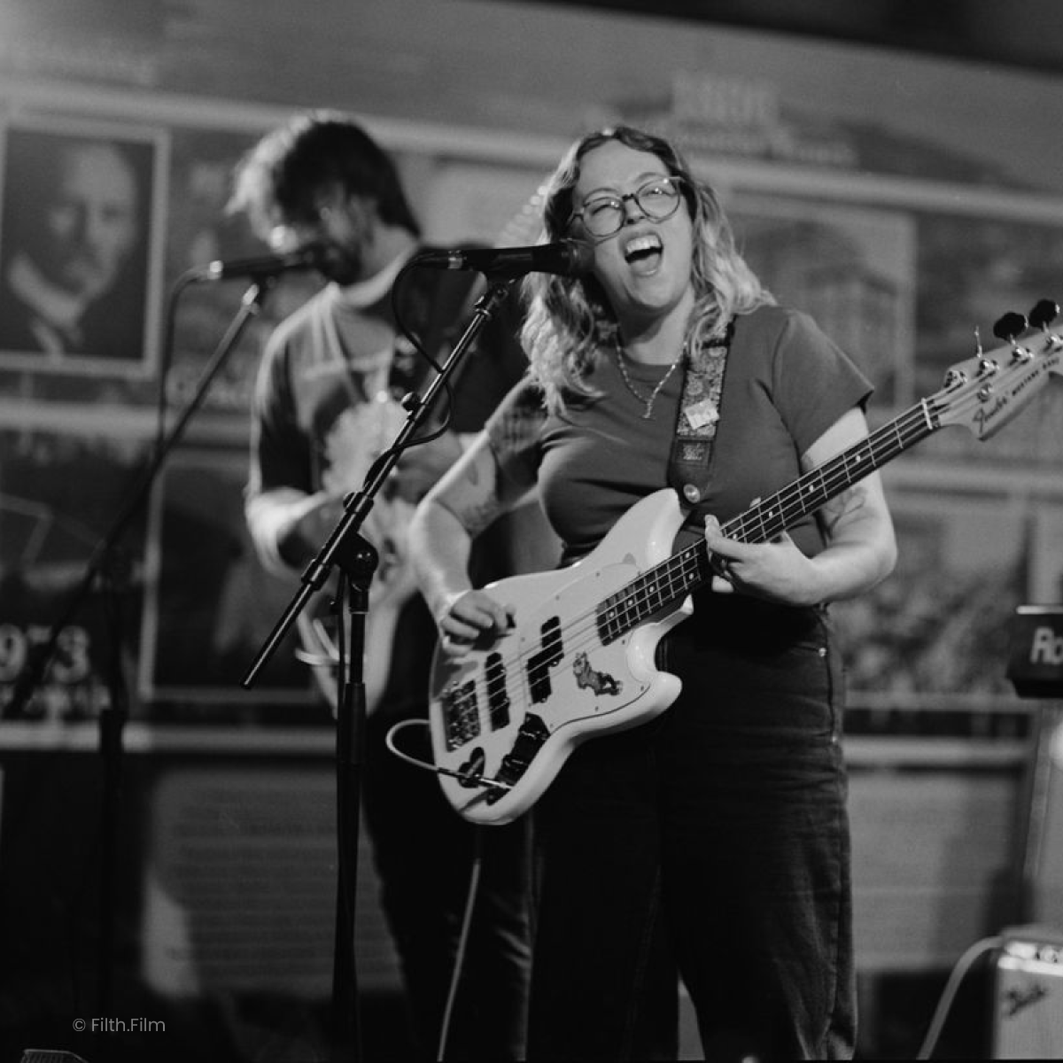 The female bassist of Not Good Not Bad sings passionately on stage at Earp Distilling Co. Image C Filth.Film